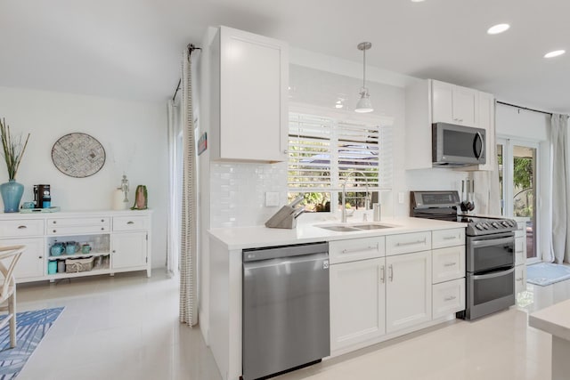 kitchen with appliances with stainless steel finishes, a sink, decorative backsplash, white cabinets, and recessed lighting