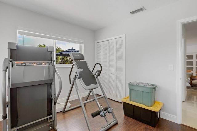exercise area featuring wood finished floors and baseboards