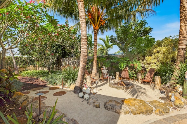 view of yard featuring a patio area, an outdoor fire pit, and fence