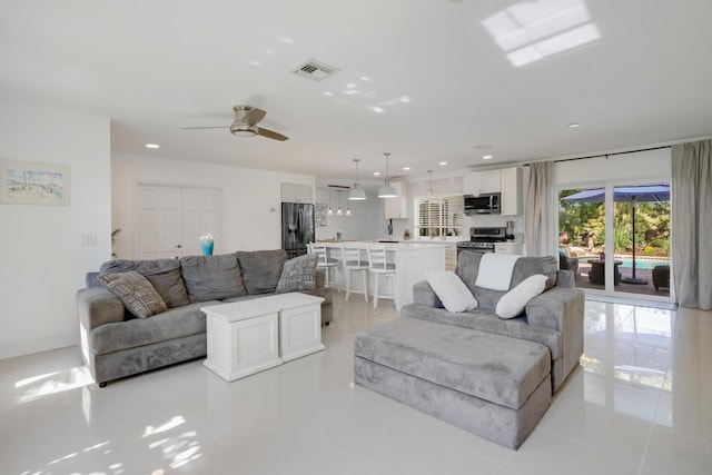 living area featuring a ceiling fan, recessed lighting, light tile patterned floors, and baseboards