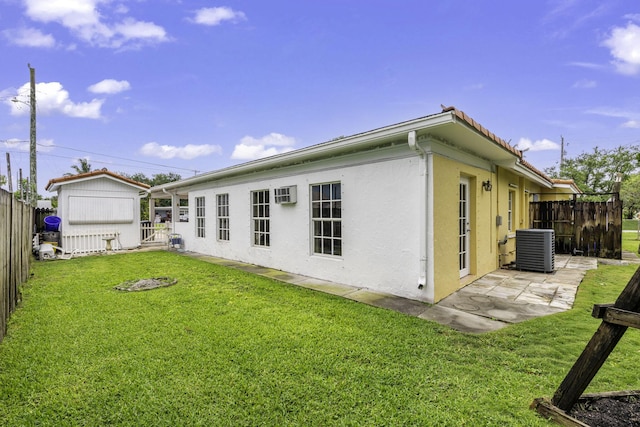 1401 Shore Dr, Lake Clarke Shores, FL 33406 - back of house with central air condition unit, stucco siding, a patio, a shed, and an outbuilding