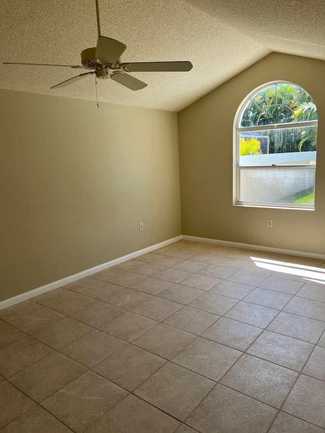 spare room featuring a ceiling fan, a textured ceiling, vaulted ceiling, and light tile patterned flooring