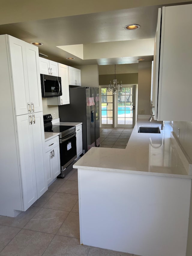 kitchen featuring black electric range, light tile patterned floors, a chandelier, white cabinetry, and recessed lighting