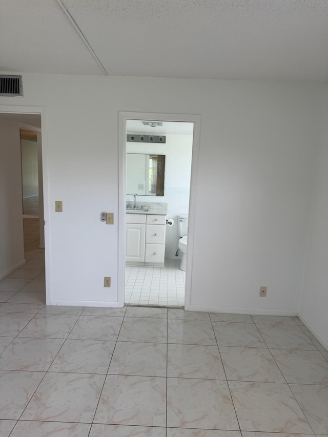 unfurnished room with a sink and baseboards