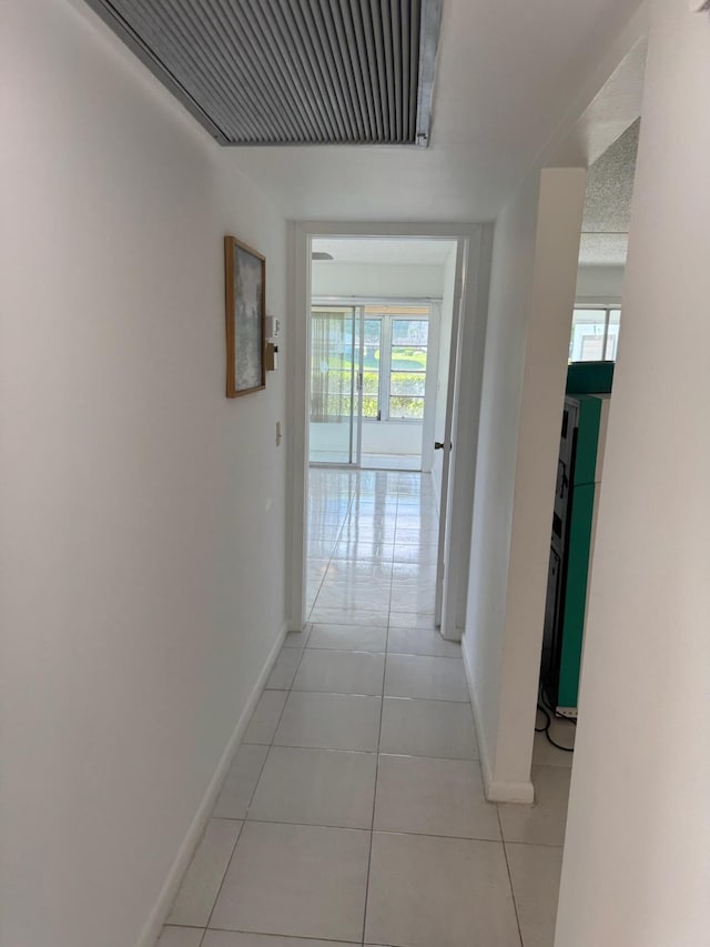 corridor with baseboards and light tile patterned floors