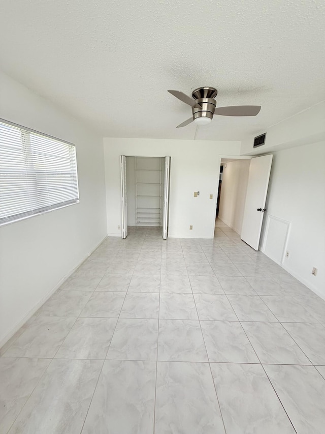 1036 Hythe B B, Boca Raton, FL 33434 - spare room featuring a ceiling fan and a textured ceiling