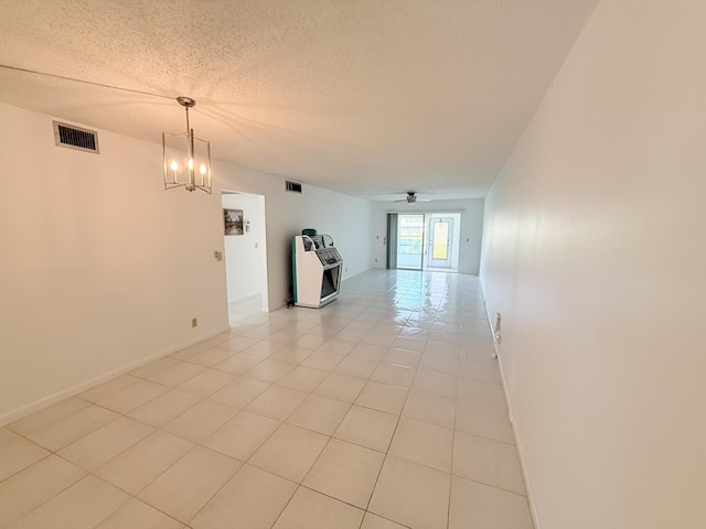 1036 Hythe B B, Boca Raton, FL 33434 - empty room featuring a ceiling fan, light tile patterned floors, a textured ceiling, and a chandelier