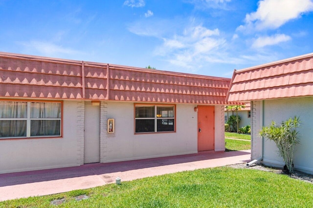 266 Seville L, Delray Beach, FL 33446 - view of front of property featuring a pergola, a front yard, mansard roof, stucco siding, and a patio area