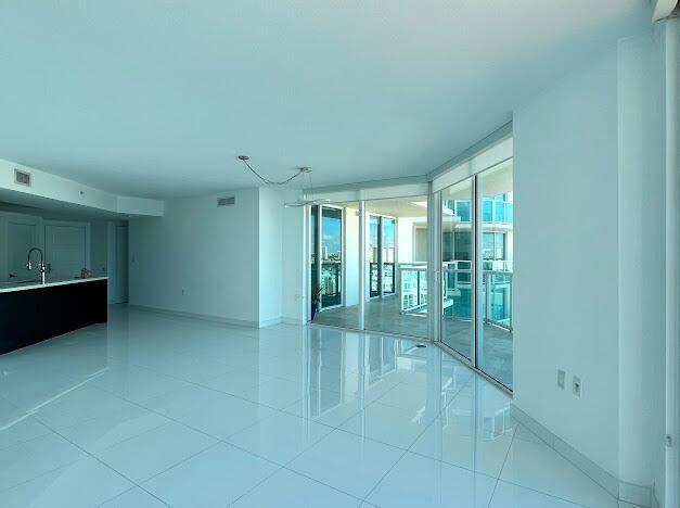 spare room with baseboards, light tile patterned floors, and floor to ceiling windows