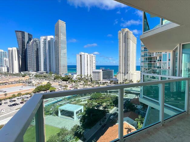 balcony featuring a skyline view and a water view