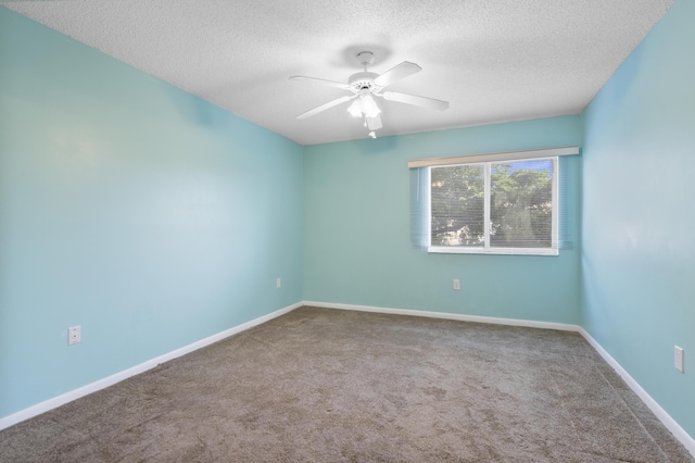 carpeted empty room with a textured ceiling, a ceiling fan, and baseboards