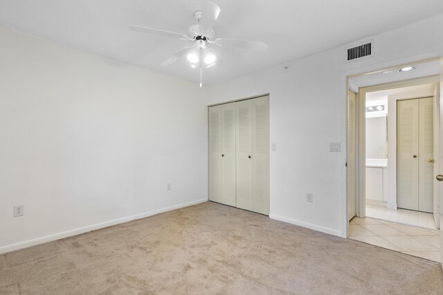 unfurnished bedroom with carpet floors, baseboards, a closet, and a ceiling fan