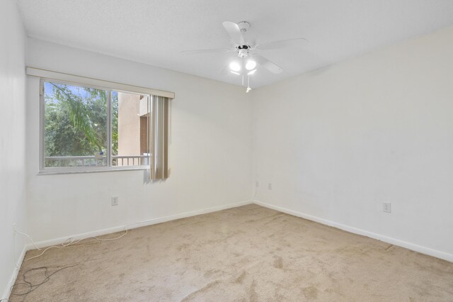 carpeted empty room with baseboards and ceiling fan