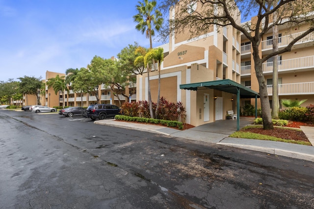 view of building exterior featuring uncovered parking and a residential view