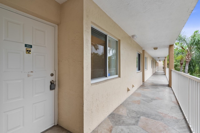property entrance with stucco siding and a balcony