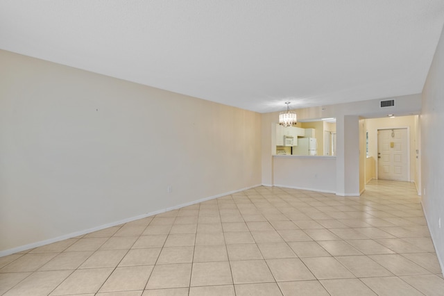 spare room with a chandelier, baseboards, and light tile patterned floors