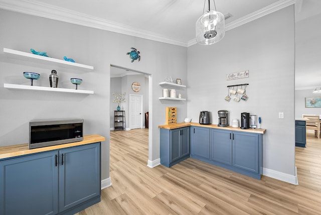 kitchen featuring blue cabinets, wooden counters, open shelves, stainless steel microwave, and crown molding
