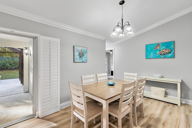 dining room featuring ornamental molding, a chandelier, light wood finished floors, and baseboards