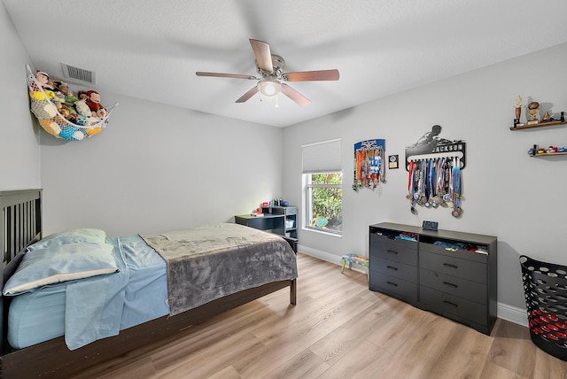 bedroom featuring wood finished floors, baseboards, and ceiling fan