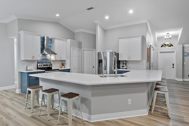 2160 SW Panther Trce, Stuart, FL 34997 - kitchen featuring wall chimney exhaust hood, appliances with stainless steel finishes, a breakfast bar, light countertops, and white cabinets