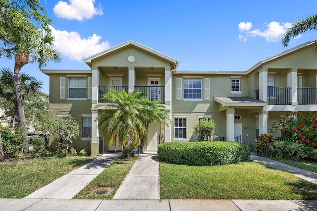2149 SE Grand Dr, Port Saint Lucie, FL 34952 - view of property featuring a balcony, stucco siding, and a front lawn