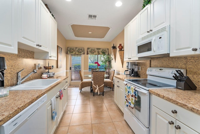 2149 SE Grand Dr, Port Saint Lucie, FL 34952 - kitchen featuring white appliances, a sink, white cabinetry, light countertops, and decorative backsplash