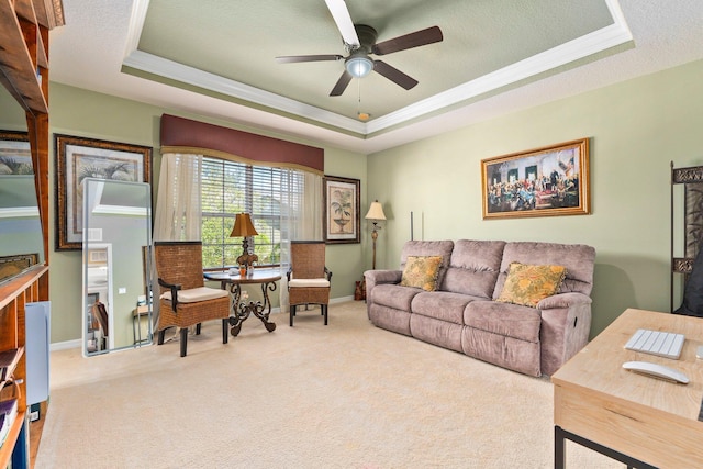 2149 SE Grand Dr, Port Saint Lucie, FL 34952 - carpeted living room with a raised ceiling, a ceiling fan, ornamental molding, baseboards, and a textured ceiling
