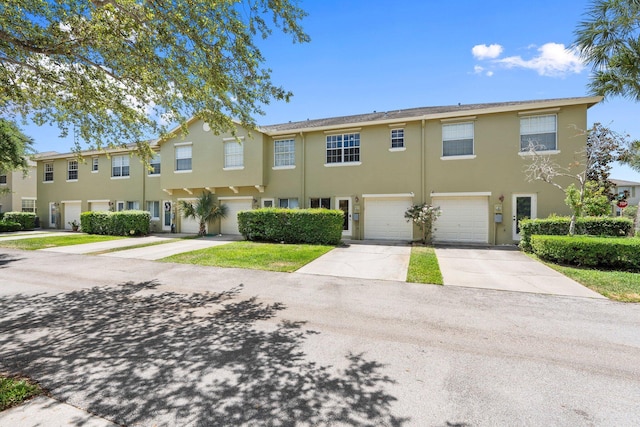 2149 SE Grand Dr, Port Saint Lucie, FL 34952 - townhome / multi-family property with driveway, stucco siding, and an attached garage