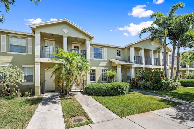 2149 SE Grand Dr, Port Saint Lucie, FL 34952 - view of front facade featuring a balcony, stucco siding, and a front lawn
