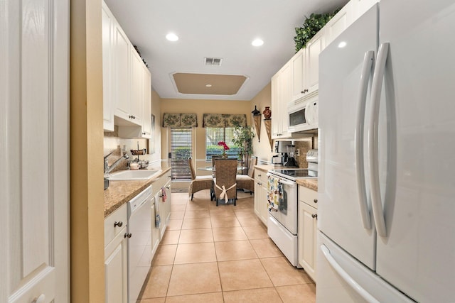 2149 SE Grand Dr, Port Saint Lucie, FL 34952 - kitchen with white appliances, a sink, light tile patterned flooring, recessed lighting, and white cabinets