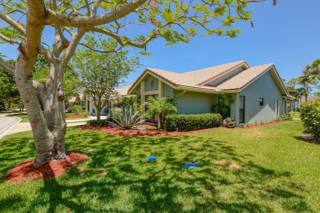 4172 Gator Trace Villas Cir Unit B, Fort Pierce, FL 34982 - view of home's exterior with a tiled roof, stucco siding, and a lawn