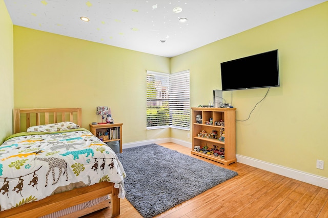 bedroom with baseboards, wood finished floors, and recessed lighting