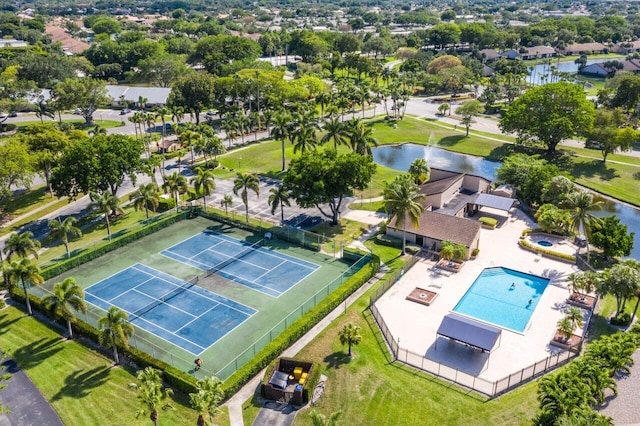 drone / aerial view of a pool area and a nearby body of water