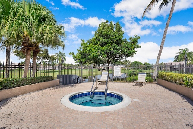 view of swimming pool with a hot tub and fence