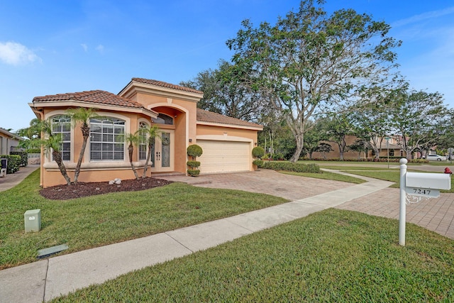 mediterranean / spanish house with stucco siding, driveway, an attached garage, and a front lawn