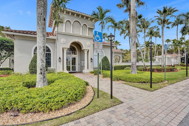 mediterranean / spanish house with stucco siding and a tile roof
