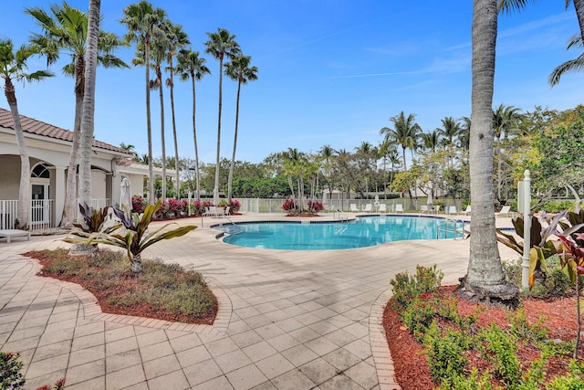 community pool featuring a patio area and fence