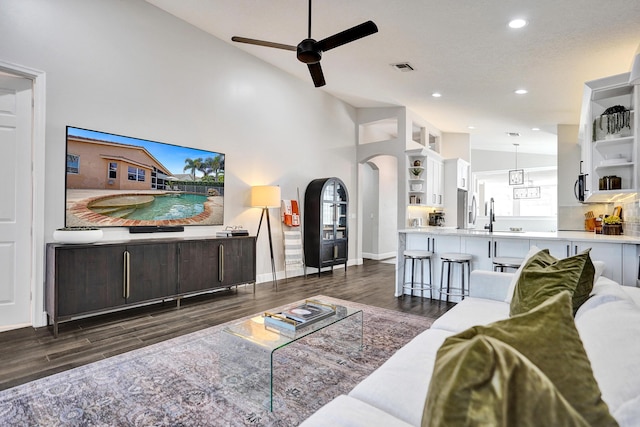 living area with arched walkways, wood finished floors, ceiling fan, recessed lighting, and baseboards