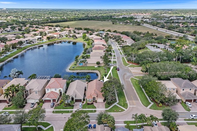 aerial view of property and surrounding area featuring nearby suburban area and a large body of water