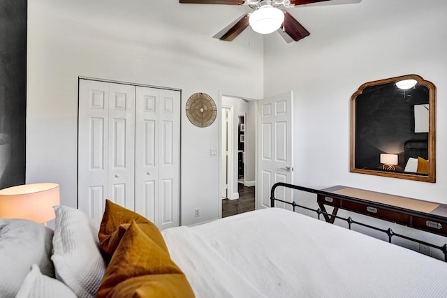 bedroom with a closet, ceiling fan, a high ceiling, and baseboards