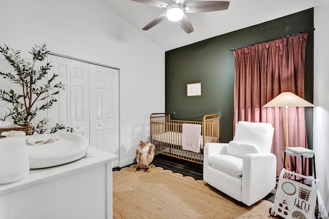 bedroom featuring a closet, ceiling fan, a nursery area, and high vaulted ceiling