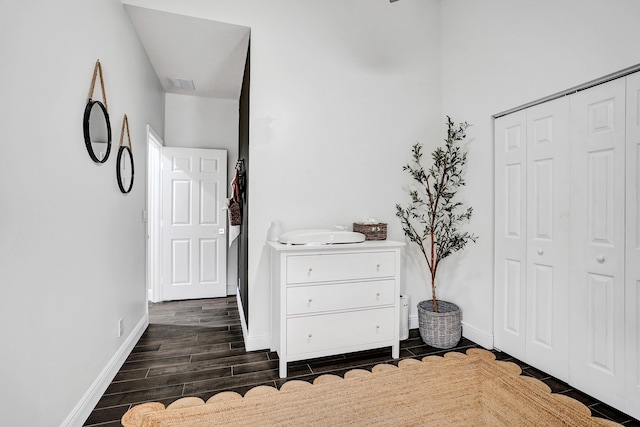 bedroom with a closet, dark wood finished floors, and baseboards