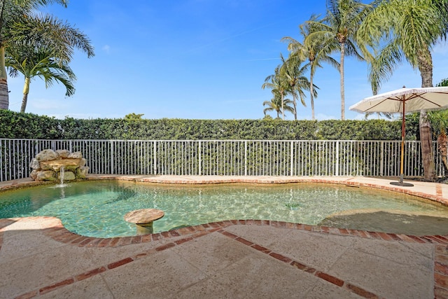 view of swimming pool featuring fence
