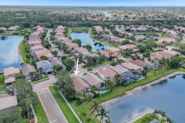 aerial view of property and surrounding area with nearby suburban area and a large body of water