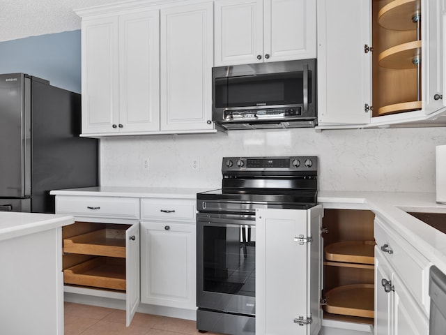 kitchen with appliances with stainless steel finishes, white cabinetry, and decorative backsplash