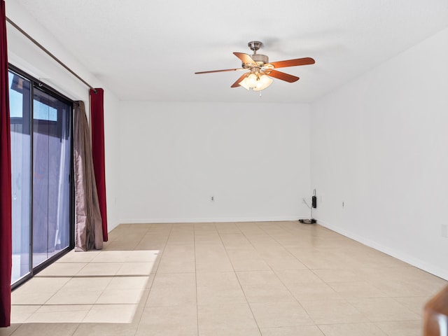 spare room with a ceiling fan and baseboards
