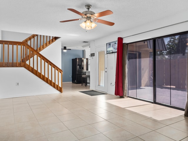 unfurnished room featuring ceiling fan, stairs, tile patterned flooring, and baseboards