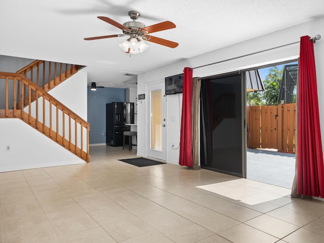 entryway with ceiling fan, stairway, tile patterned floors, and baseboards