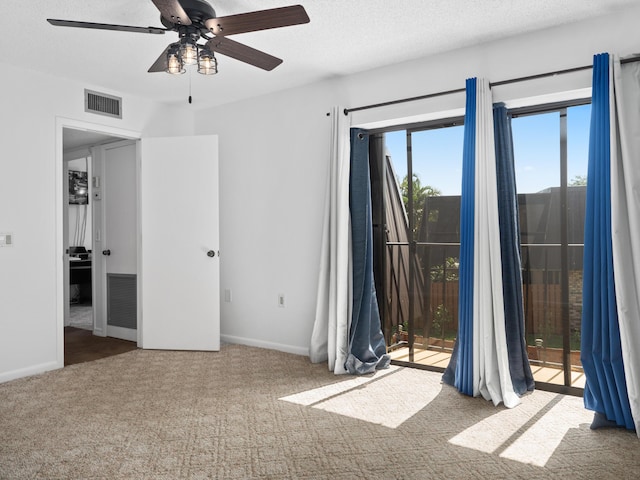 carpeted empty room with a ceiling fan and baseboards