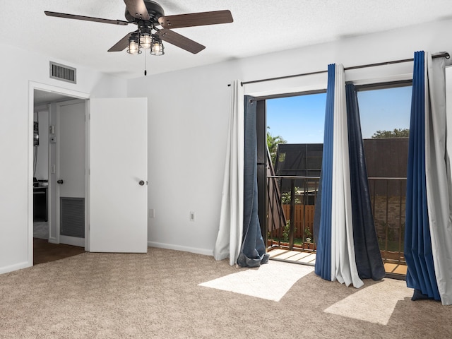 unfurnished bedroom with access to outside, carpet, baseboards, ceiling fan, and a textured ceiling